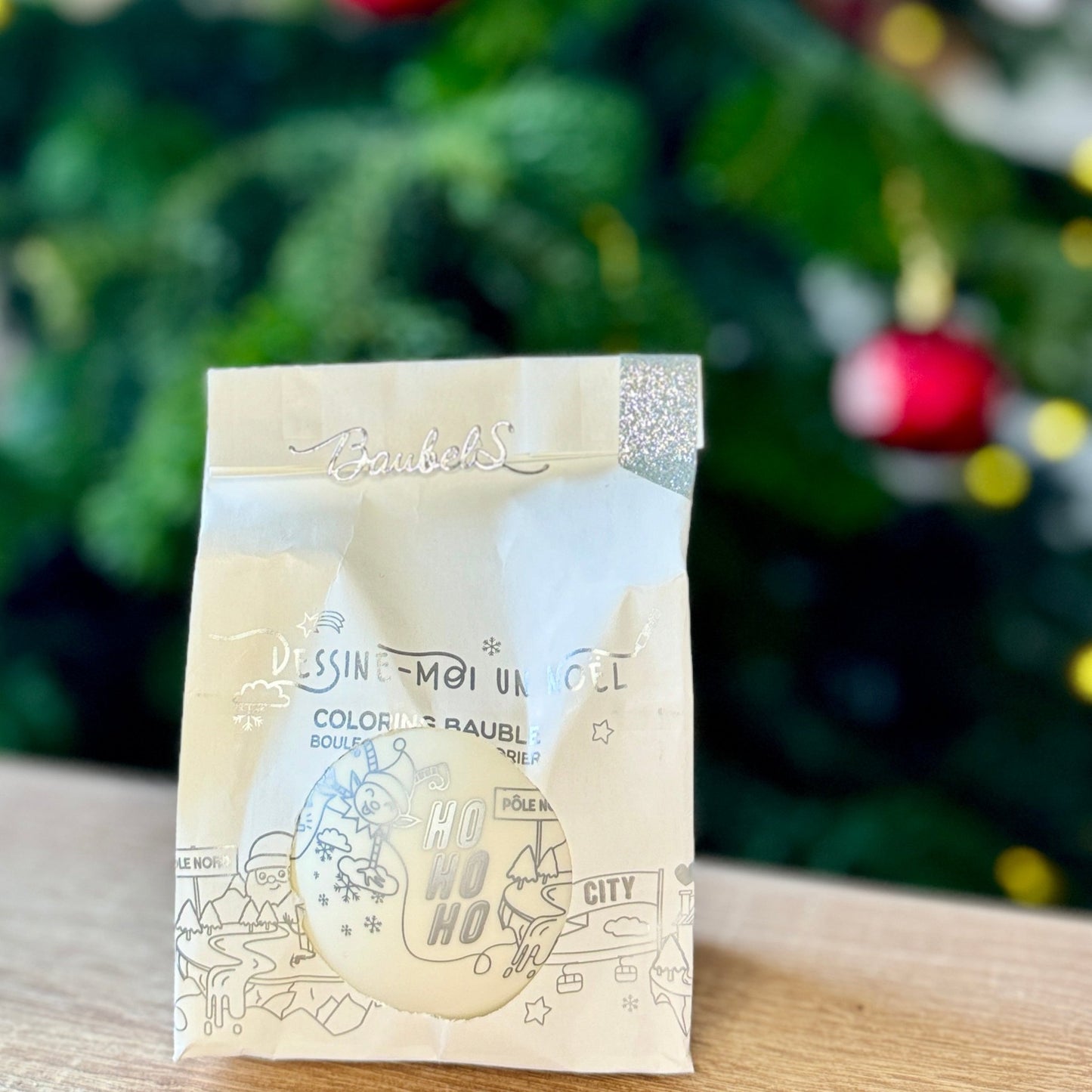 Close-up of a customizable Christmas bauble featuring a pre-printed festive design, perfect for coloring