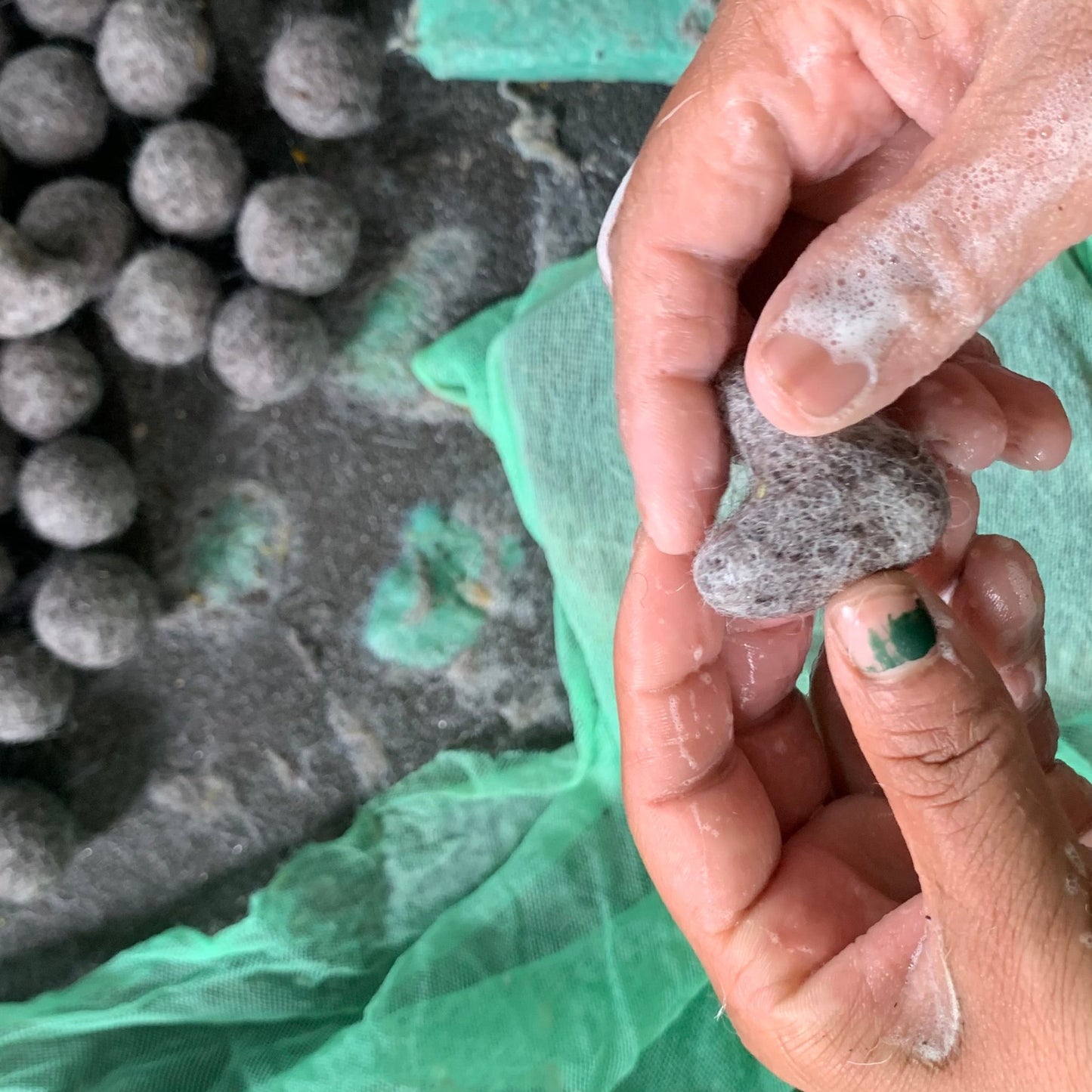 Close-up of artisan hands crafting handmade Christmas ornaments from natural New Zealand wool in Nepal, showcasing fair trade craftsmanship by Gry & Sif