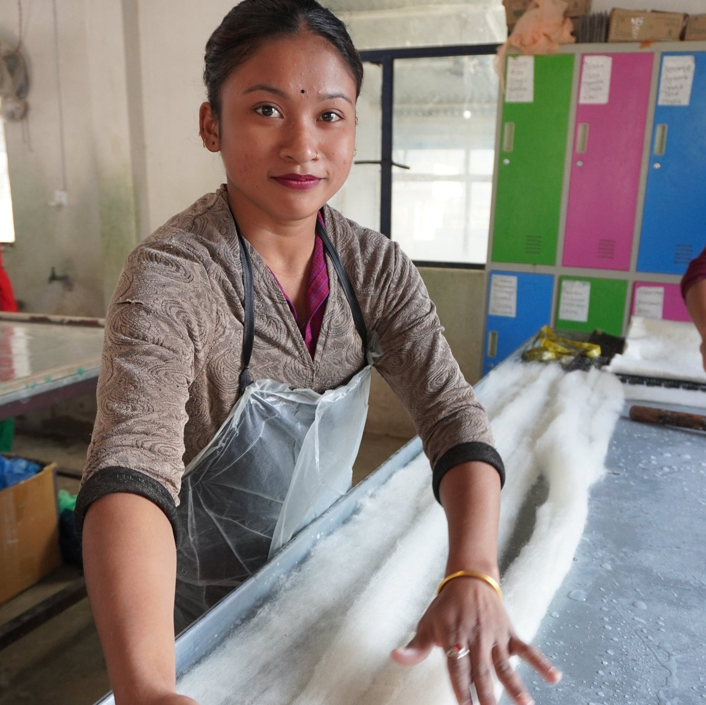 Close-up of artisan hands crafting handmade wool heart ornaments for Christmas decor, made from natural New Zealand wool in Nepal under fair trade conditions by Gry & Sif