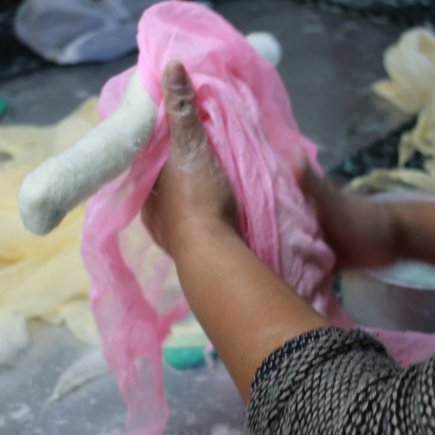 a Nepali artisan supported by Gry & Sif’s fair trade practices, crafting handmade wool bell ornaments as unique holiday decor and thoughtful gifts